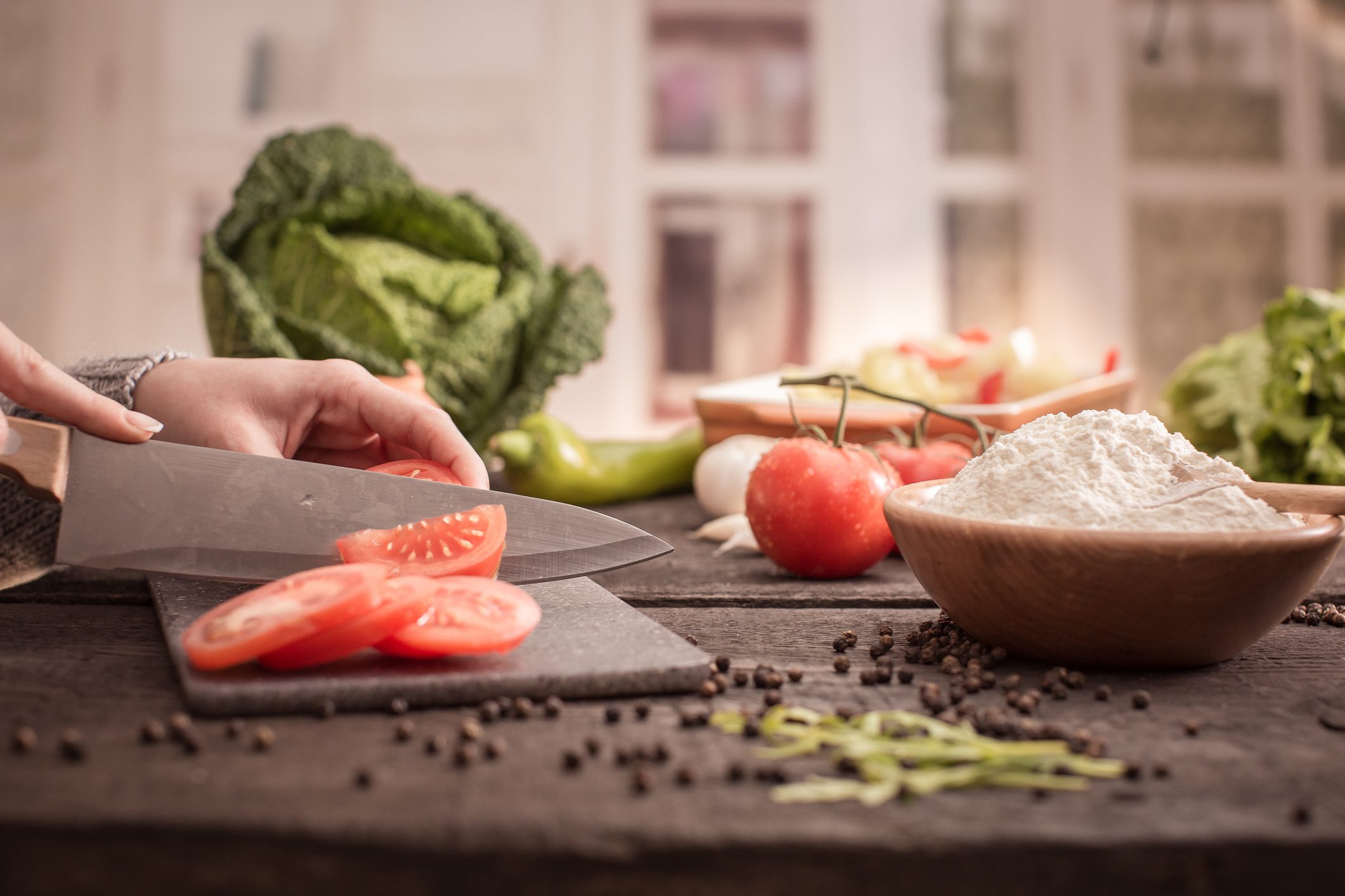 Fresh vegetables and flour on kitchen counter